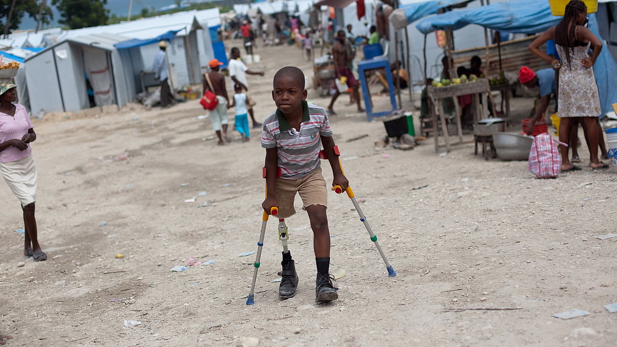 Sebastien (10) zips around the temporary tent camp where he lives after the earthquake.