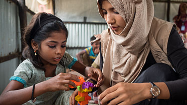 Child and teacher play in a child-friendly space in a Rohingya refugee camp ©CBM/ Hayduk